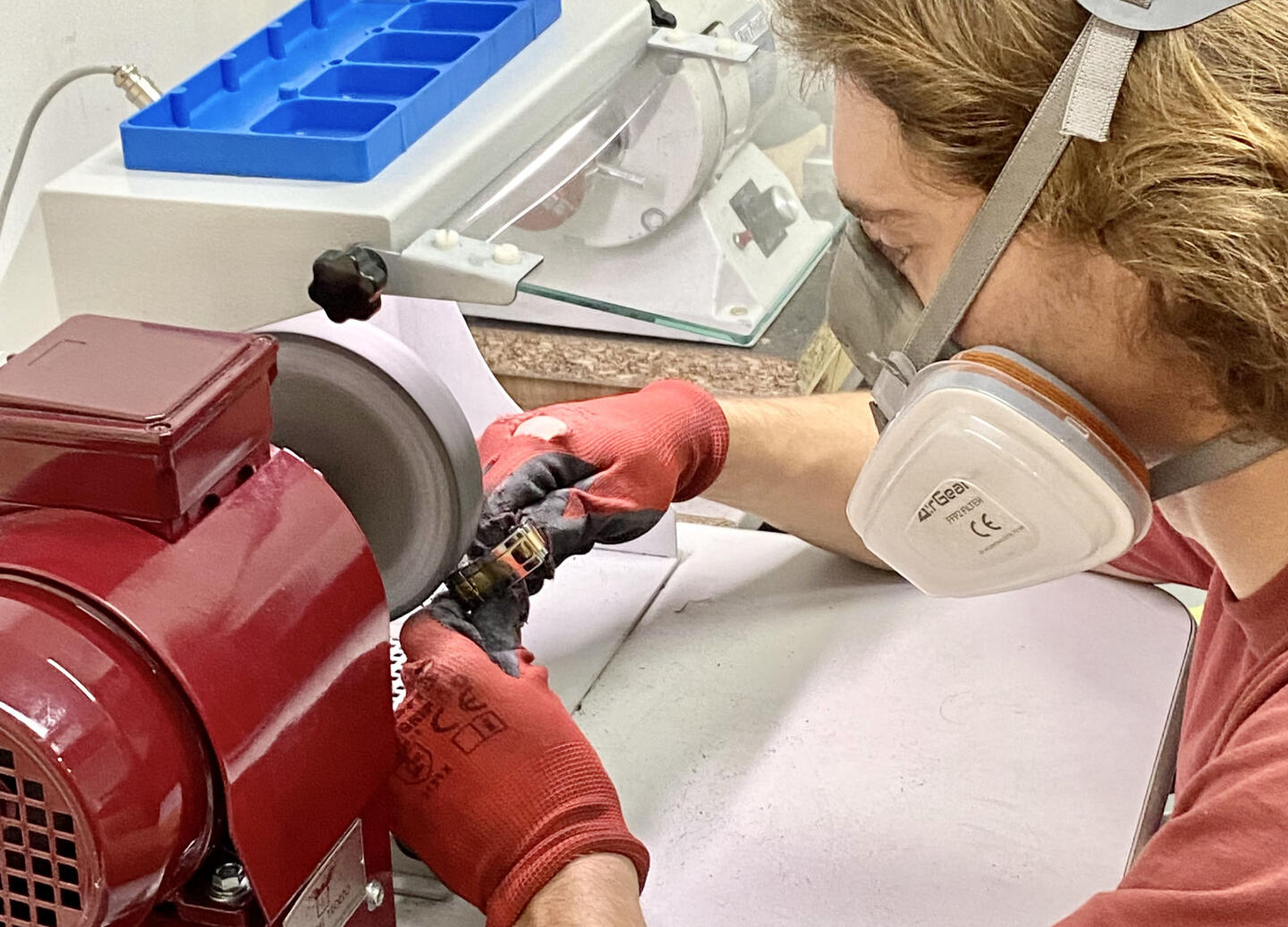 A professional watch polisher working on a vintage Rolex bracelet in steel.